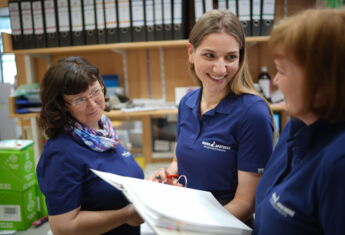 Sie sehen freundliche Mitarbeiterin im Backoffice der Apotheke.